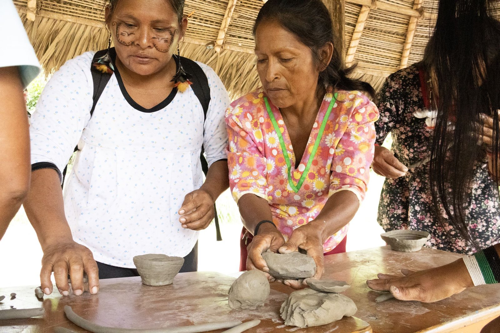 Maestras ceramistas de Wichim modelando piezas juntas